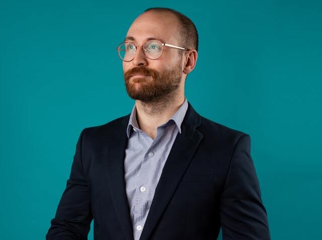 Man holding a phone and wearing a blazer